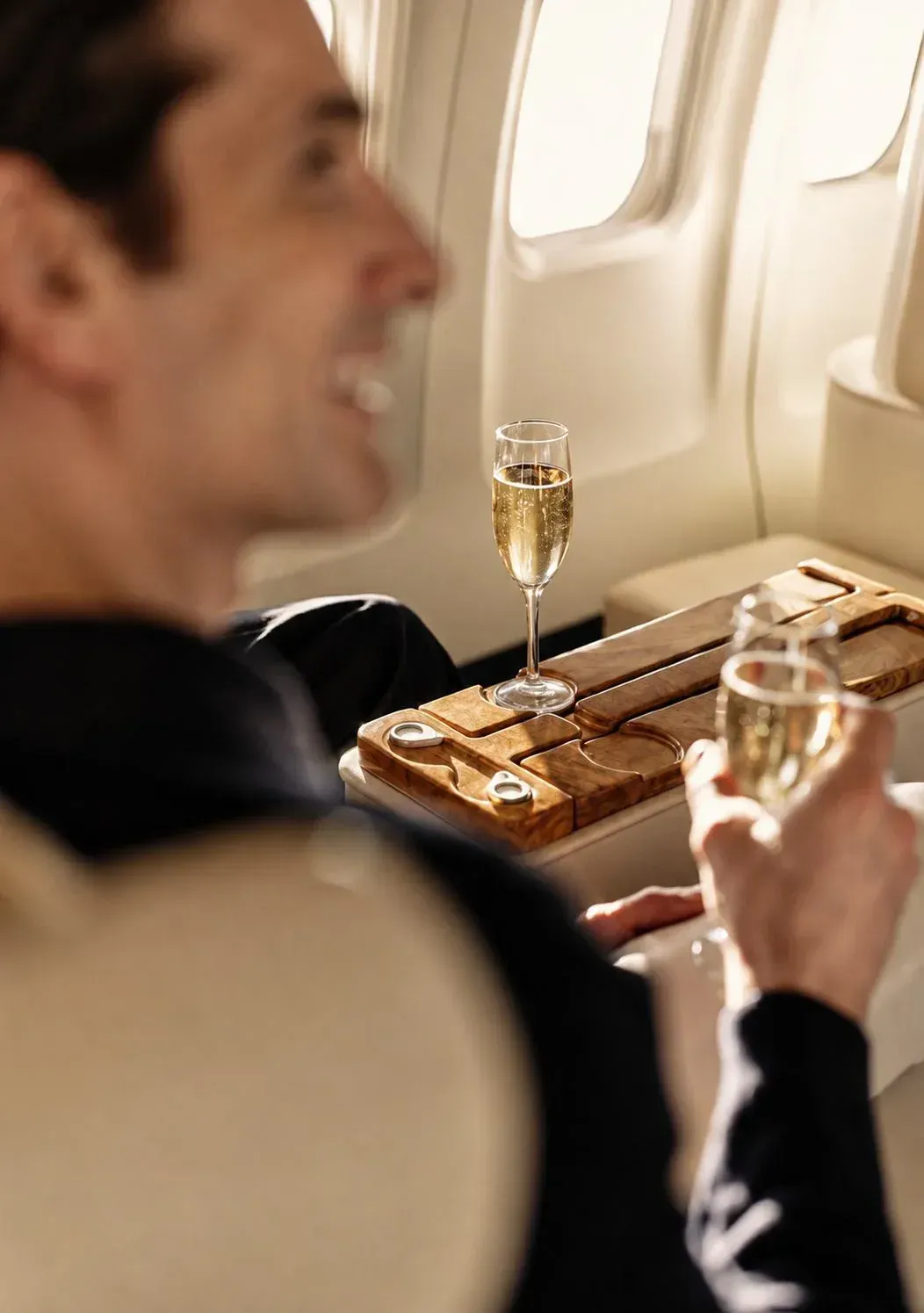A traveller relaxing with champagne in a private premium cabin